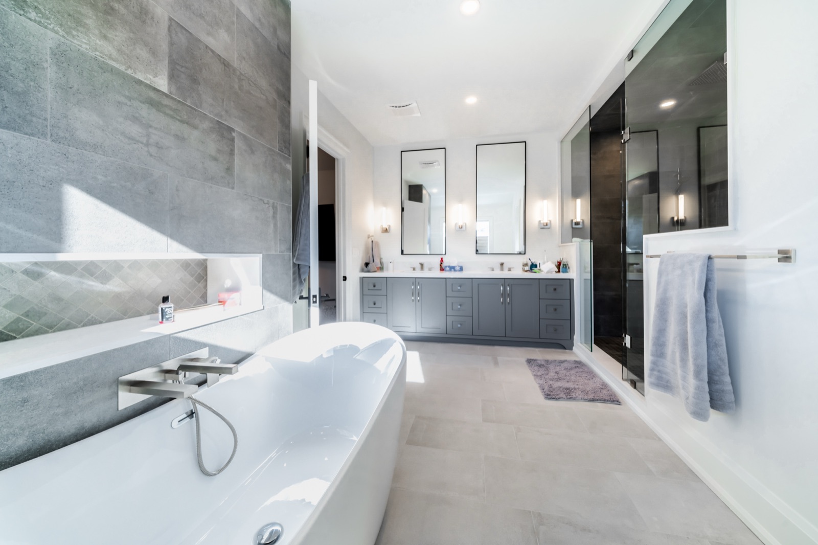 Modern grey bathroom with freestanding tub and glass shower
