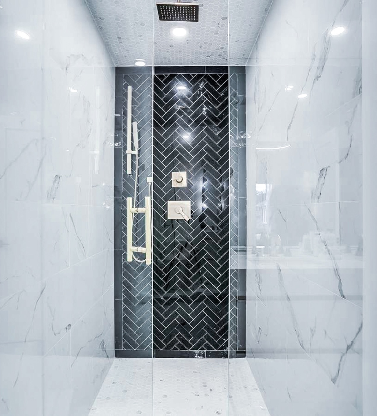 Walk-in shower with black herringbone feature wall and marble surround