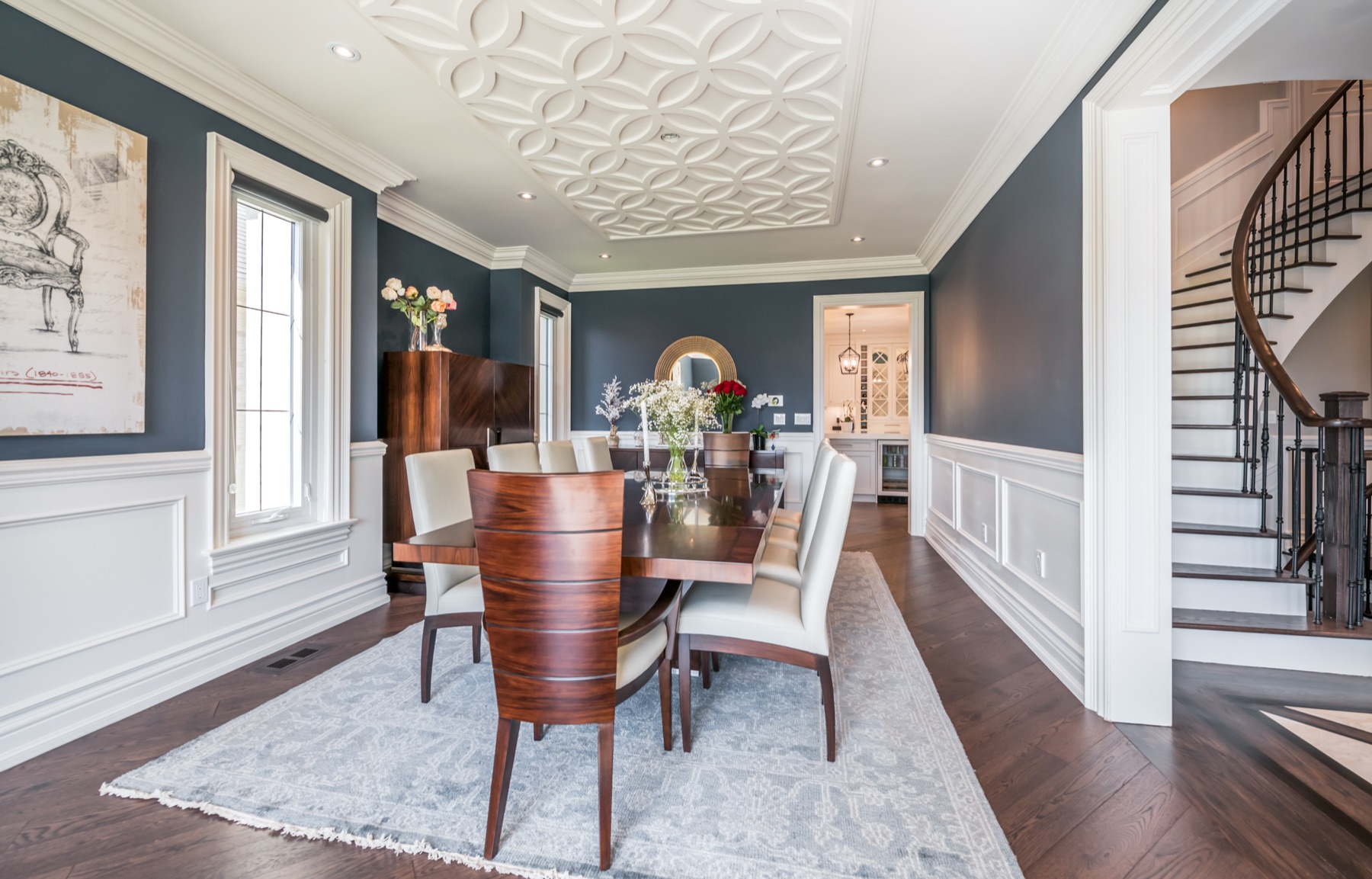 Formal dining room with navy walls, wainscoting and sculpted ceiling medallion