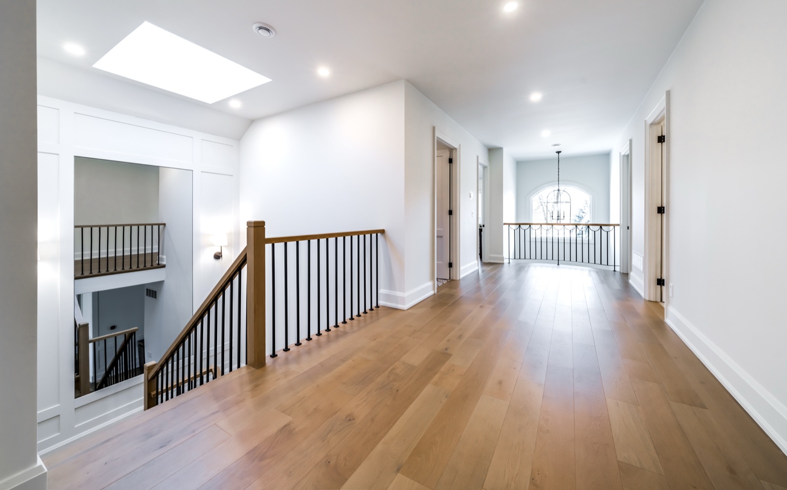 Upper hallway with skylight, oak floors and iron railing