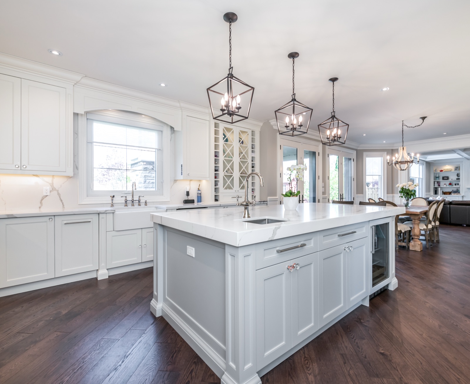 Luxury white kitchen with marble island and iron lantern pendants