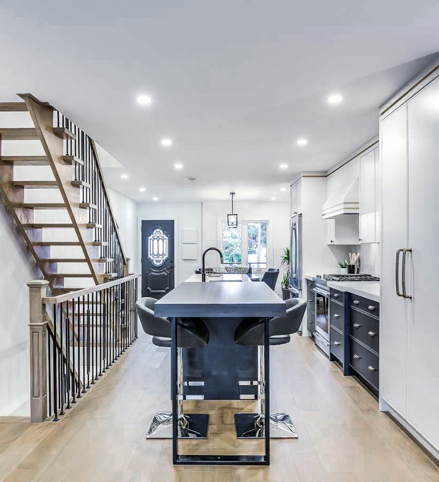 Navy and white kitchen with black island and open stair